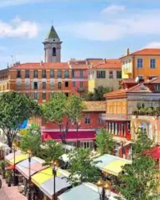 a large building with a clock tower in a city at Une atypique et merveilleuse Petite maison en plein cœur de Nice, à proximité de la mer et des plages in Nice