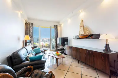 a living room with a couch and a sailboat on the wall at LE FRANCE AP4350 By Riviera Holiday Homes in Nice