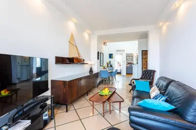 a living room with a leather couch and a tv at LE FRANCE AP4350 By Riviera Holiday Homes in Nice
