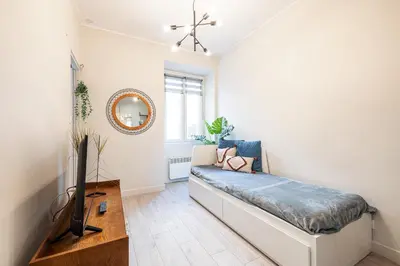 a living room with a couch and a tv at Le GRAND JEAN - CENTRAL PRES GARE ET TRAM - supermarchés - WIFI - 3 Person in Nice