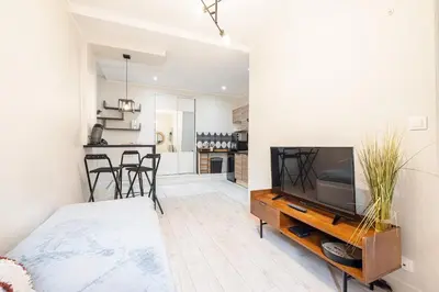 a living room with a television on a wooden entertainment center at Le GRAND JEAN - CENTRAL PRES GARE ET TRAM - supermarchés - WIFI - 3 Person in Nice