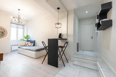 a living room with a table and chairs and a couch at Le GRAND JEAN - CENTRAL PRES GARE ET TRAM - supermarchés - WIFI - 3 Person in Nice