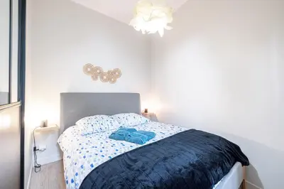 a bedroom with a bed with a blue comforter at Le GRAND JEAN - CENTRAL PRES GARE ET TRAM - supermarchés - WIFI - 3 Person in Nice