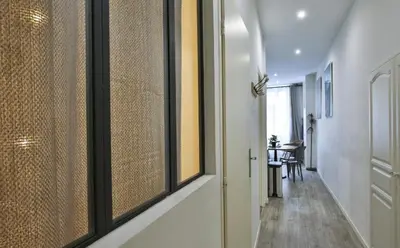 a living room with a table and a kitchen at Appartement coeur du vieux Nice in Nice