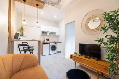 a living room with a couch and a television on a table at Le PETIT JEAN- CENTRAL PRES GARE ET TRAM - supermarchés - WIFI - in Nice