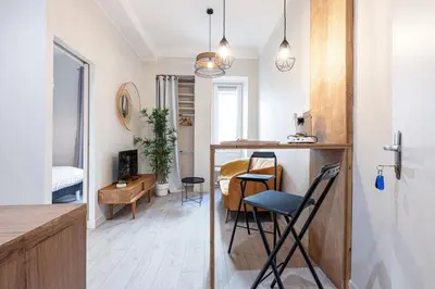 a kitchen and a living room with a table and chairs at Le PETIT JEAN- CENTRAL PRES GARE ET TRAM - supermarchés - WIFI - in Nice