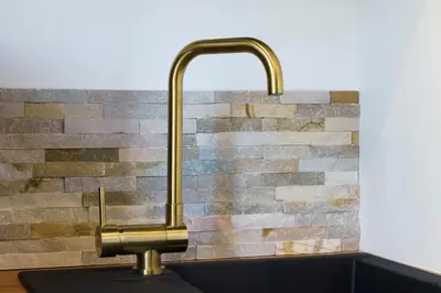 a kitchen sink with a brass faucet on a counter at Nice Renting - MAETERLINCK - Idyllic Luxury Retreat in Cap de Nice Sea View in Nice
