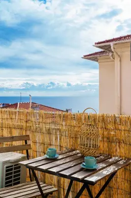 a wooden table with two cups and a basket on a balcony at Nice Renting - MAETERLINCK - Idyllic Luxury Retreat in Cap de Nice Sea View in Nice