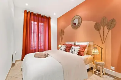 a bedroom with a large bed with orange walls at Nice - Renting - LASCARIS - Charm & Spacious & Comfort 3P Port Bonaparte in Nice