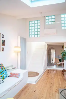 a living room with a white couch and stairs at Duplex au cœur du vieux Nice in Nice