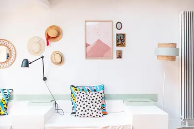 a white living room with a couch and a lamp at Duplex au cœur du vieux Nice in Nice