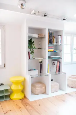 a white book shelf with a yellow stool in a room at Duplex au cœur du vieux Nice in Nice