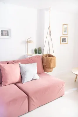 a pink couch with pillows in a living room at Duplex au cœur du vieux Nice in Nice