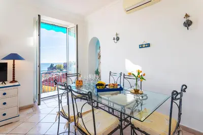 a dining room with a glass table and a view of the ocean at VOLTI ON THE BAY AP4386 By Riviera Holiday Homes in Villefranche-sur-Mer