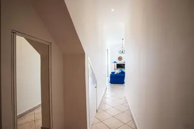 a hallway with a white wall and an open door at VOLTI ON THE BAY AP4386 By Riviera Holiday Homes in Villefranche-sur-Mer
