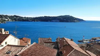 a view of a large body of water with houses at VOLTI ON THE BAY AP4386 By Riviera Holiday Homes in Villefranche-sur-Mer