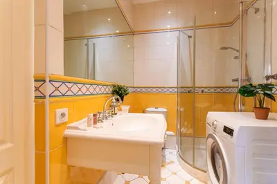 a bathroom with a sink and a shower and a washing machine at VOLTI ON THE BAY AP4386 By Riviera Holiday Homes in Villefranche-sur-Mer