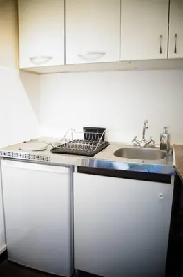 a kitchen with a sink and a dish rack on a counter at Charming studio overlooking a beautiful garden in Nice
