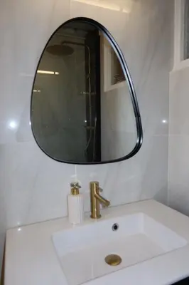 a bathroom sink with a mirror on top of it at Charming studio overlooking a beautiful garden in Nice
