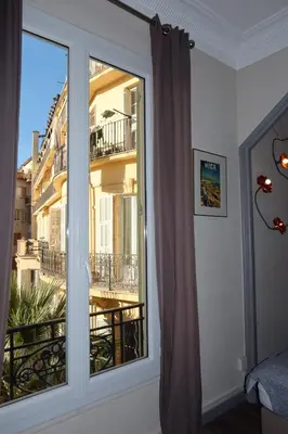 a room with a window with a view of a building at Charming studio overlooking a beautiful garden in Nice