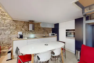 a kitchen with a white table and red chairs at Loft Gambetta 33 Fshh in Nice