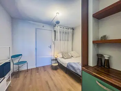 a small bedroom with a bed and a chair at Le Baccarat - Wifi, AC, vue mer, 4 pers in Nice