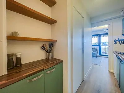 a kitchen with a green cabinet and a hallway at Le Baccarat - Wifi, AC, vue mer, 4 pers in Nice