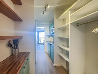 a kitchen with white walls and a hallway with shelves at Le Baccarat - Wifi, AC, vue mer, 4 pers in Nice