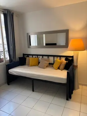 a bed with yellow pillows and a lamp in a room at Centre ville in Nice