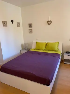 a bedroom with a large bed with purple and yellow sheets at Centre ville in Nice