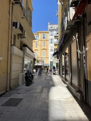 a city street with a motorcycle parked on the sidewalk at Centre ville in Nice