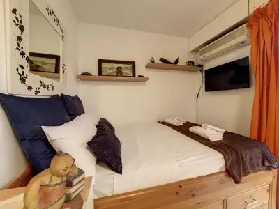 a small bedroom with a bed and a tv at Nestor&Jeeves - FLORIDA BEACH - Studio with balcony in Nice