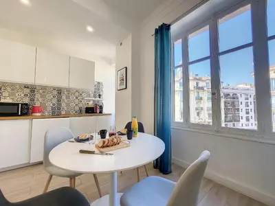 a kitchen with a table and chairs and a window at Nestor&Jeeves - BLEU BUFFA - Central location in Nice