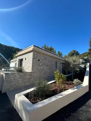 a brick house with a garden in front of it at Appartement neuf coup de coeur entre Èze et Monaco in Èze