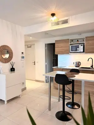 a kitchen with a counter and stools in a room at Appartement neuf coup de coeur entre Èze et Monaco in Èze