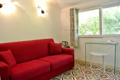 a red couch in a living room with a window at Villa Bellabé in Nice