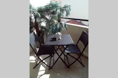 a table and chairs on a balcony with palm trees at Villa Tobias in Nice