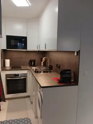 a kitchen with white cabinets and a sink at Villa Tobias in Nice