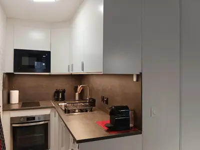 a kitchen with white cabinets and a toaster oven at Villa Tobias in Nice