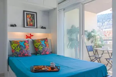 a bedroom with a blue bed with a tray of food on it at Villa Tobias in Nice