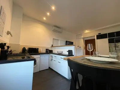 a kitchen with white cabinets and a counter top at Charmant Studio - Port de Nice in Nice