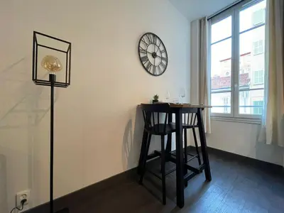 a room with a table and a clock on the wall at Charmant Studio - Port de Nice in Nice