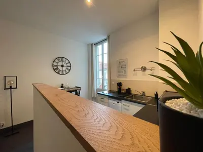 a kitchen with a counter and a clock on the wall at Charmant Studio - Port de Nice in Nice