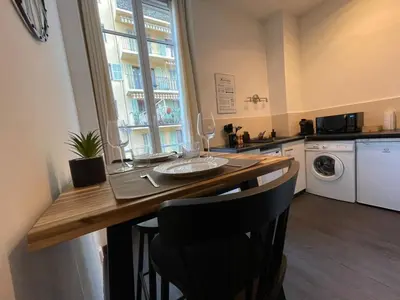 a kitchen with a table with chairs and a window at Charmant Studio - Port de Nice in Nice