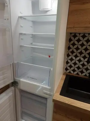 an empty refrigerator with its door open in a kitchen at Cosy Haven 5 min from Nice Carnival Hyper-Center! in Nice