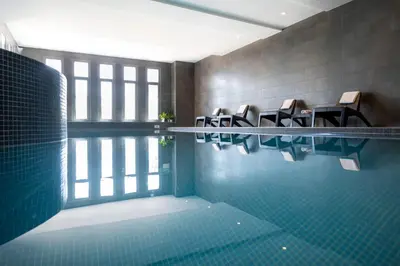 a swimming pool with a bunch of chairs in a room at Nemea Appart Hotel Nice Arenas Aéroport in Nice