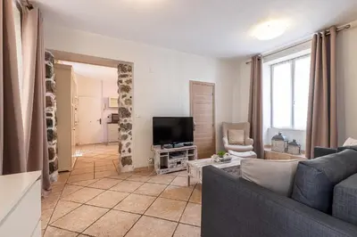 a living room with a couch and a tv at Cozy 1 Bdr at Nice Port in Nice
