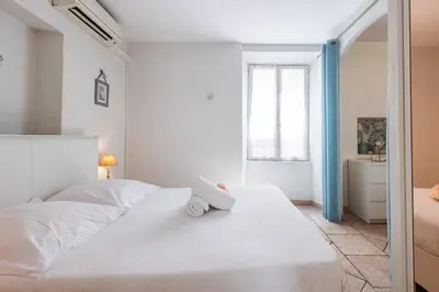a bedroom with a large white bed with a book on it at Cozy 1 Bdr at Nice Port in Nice