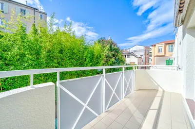 a balcony with a white fence and trees at Le calme à Nissa la Bella in Nice