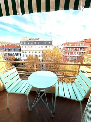 a balcony with two chairs and a table and a view at Happy Home spacieux studio en dernier étage avec balcon à 5 minutes à pieds du vieux Nice et de la mer Quartier Dubouchage in Nice